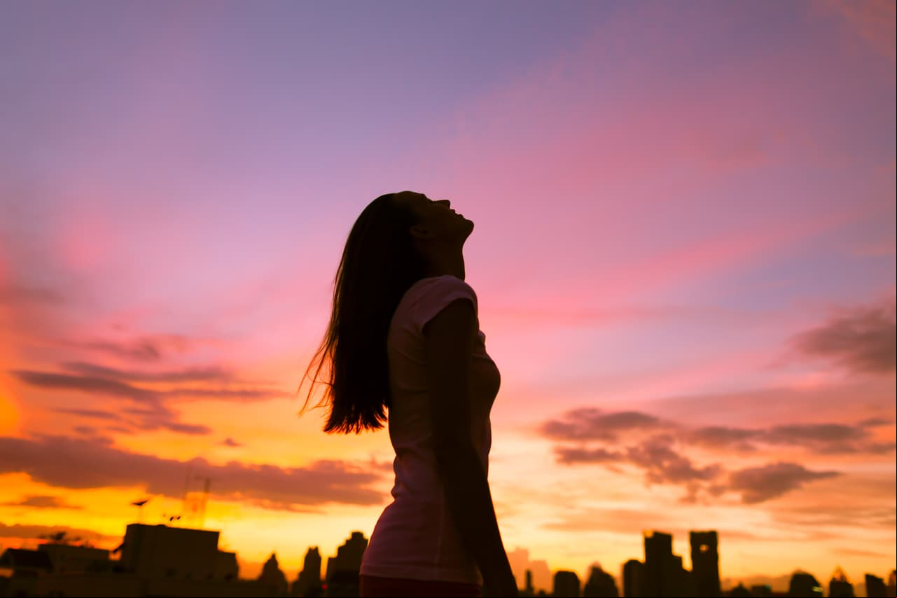 Happy,Woman,In,The,City,Looking,Up,Into,The,Sky.